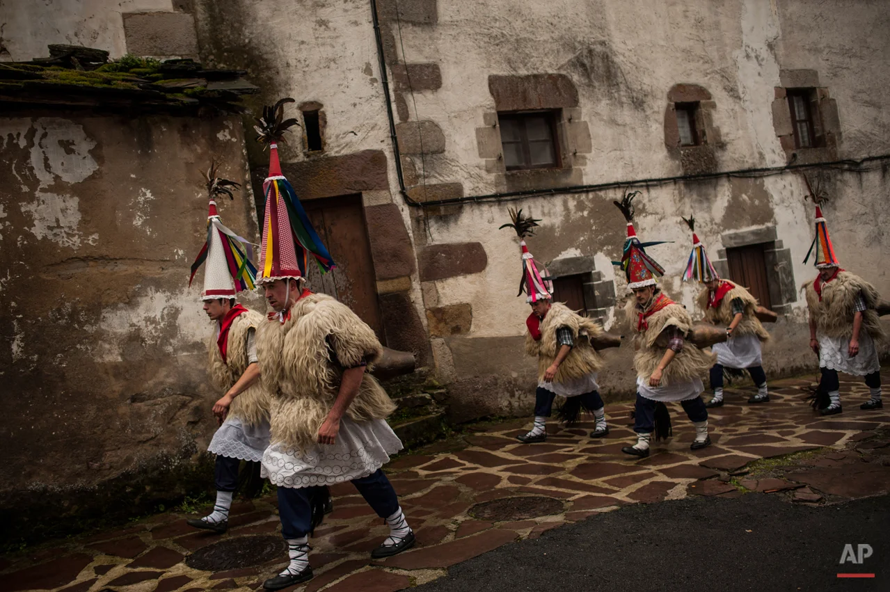 In this photo taken on Tuesday, Jan. 27, 2015 Joaldunaks, some to call them ''Zanpantzar'', take part on the Carnival between of the Pyrenees villages of Ituren and Zubieta, northern Spain. While Rio de Janeiro may boast the worldís most famous carnival, the festive period of masquerades and wild and colorful costumes that precedes the Christian religious season of Lent is also a permanent and popular fixture for celebration in Spain and Portugal, with each country having its own strange and unique way of doing it. The Pyrenees villages of Ituren and Zubieta stage one of Europeís most ancient carnivals _ dating from Roman times _ where residents dress up as figures known as ëJoaldunak,í _ or cowbells _ and parade the streets with sheepskins around the waist and shoulder, conical caps and cowbells on their back. (AP Photo/Alvaro Barrientos)