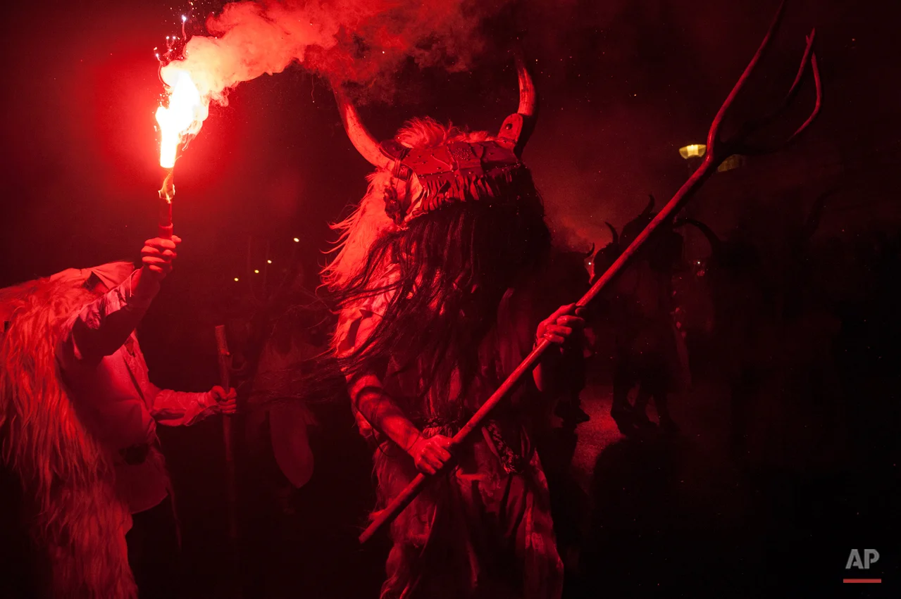 In this photo taken on Tuesday, Feb. 17, 2015 a ''Momotxorro'' takes part in the carnival wearing his typical carnival dress, in Alsasua, northern Spain. While Rio de Janeiro may boast the worldís most famous carnival, the festive period of masquerades and wild and colorful costumes that precedes the Christian religious season of Lent is also a permanent and popular fixture for celebration in Spain and Portugal, with each country having its own strange and unique way of doing it. Up north in Alsasua, Spain, half-man, half-bull figures known as Momotxorros smear their face as if with the blood of a sacrificed animal. Wearing horns and and red-stained, white sheets, they roam the town roaring fiercely and brandishing sticks. (AP Photo/Alvaro Barrientos)