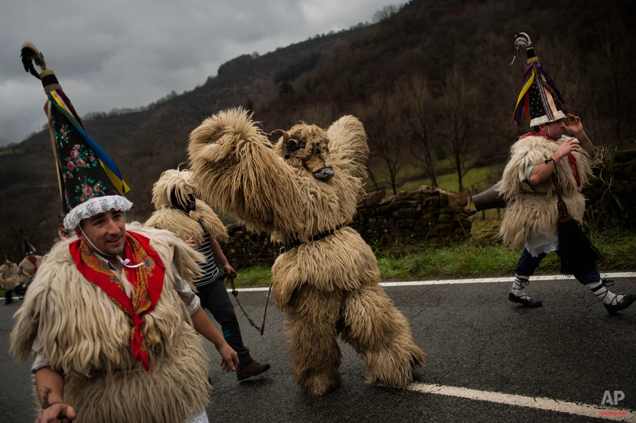 In this photo taken on Tuesday, Jan. 27, 2015 Joaldunaks, some to call them ''Zanpantzar'', take part on the Carnival between of the Pyrenees villages of Ituren and Zubieta, northern Spain. While Rio de Janeiro may boast the worldís most famous carnival, the festive period of masquerades and wild and colorful costumes that precedes the Christian religious season of Lent is also a permanent and popular fixture for celebration in Spain and Portugal, with each country having its own strange and unique way of doing it. The Pyrenees villages of Ituren and Zubieta stage one of Europeís most ancient carnivals _ dating from Roman times _ where residents dress up as figures known as ëJoaldunak,í _ or cowbells _ and parade the streets with sheepskins around the waist and shoulder, conical caps and cowbells on their back. (AP Photo/Alvaro Barrientos)