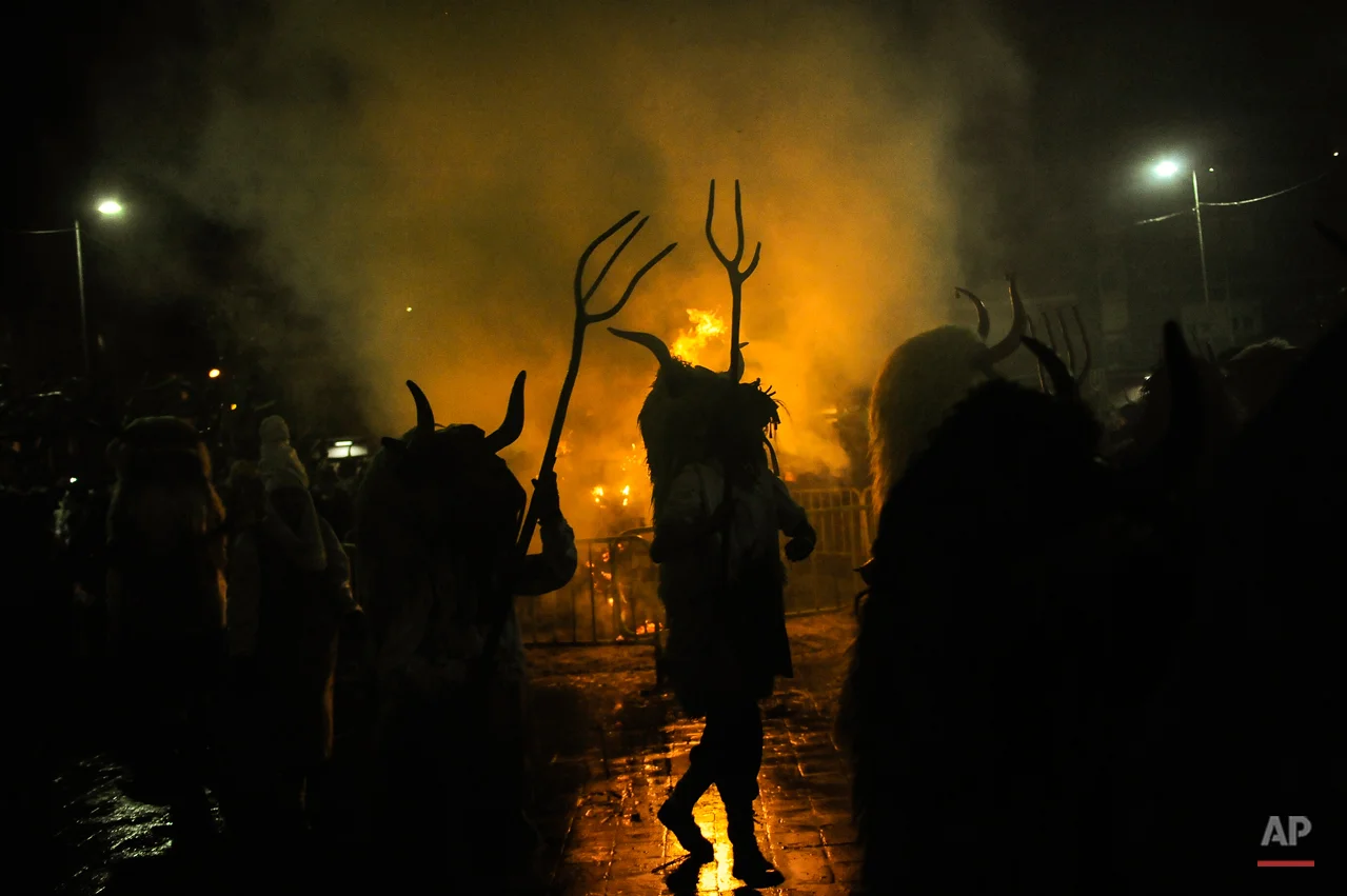 In this photo taken on Tuesday, Feb. 17, 2015 ''Momotxorros'' take part in the carnival wearing typical carnival dress, in Alsasua, northern Spain. While Rio de Janeiro may boast the worldís most famous carnival, the festive period of masquerades and wild and colorful costumes that precedes the Christian religious season of Lent is also a permanent and popular fixture for celebration in Spain and Portugal, with each country having its own strange and unique way of doing it. Up north in Alsasua, Spain, half-man, half-bull figures known as Momotxorros smear their face as if with the blood of a sacrificed animal. Wearing horns and and red-stained, white sheets, they roam the town roaring fiercely and brandishing sticks. (AP Photo/Alvaro Barrientos)