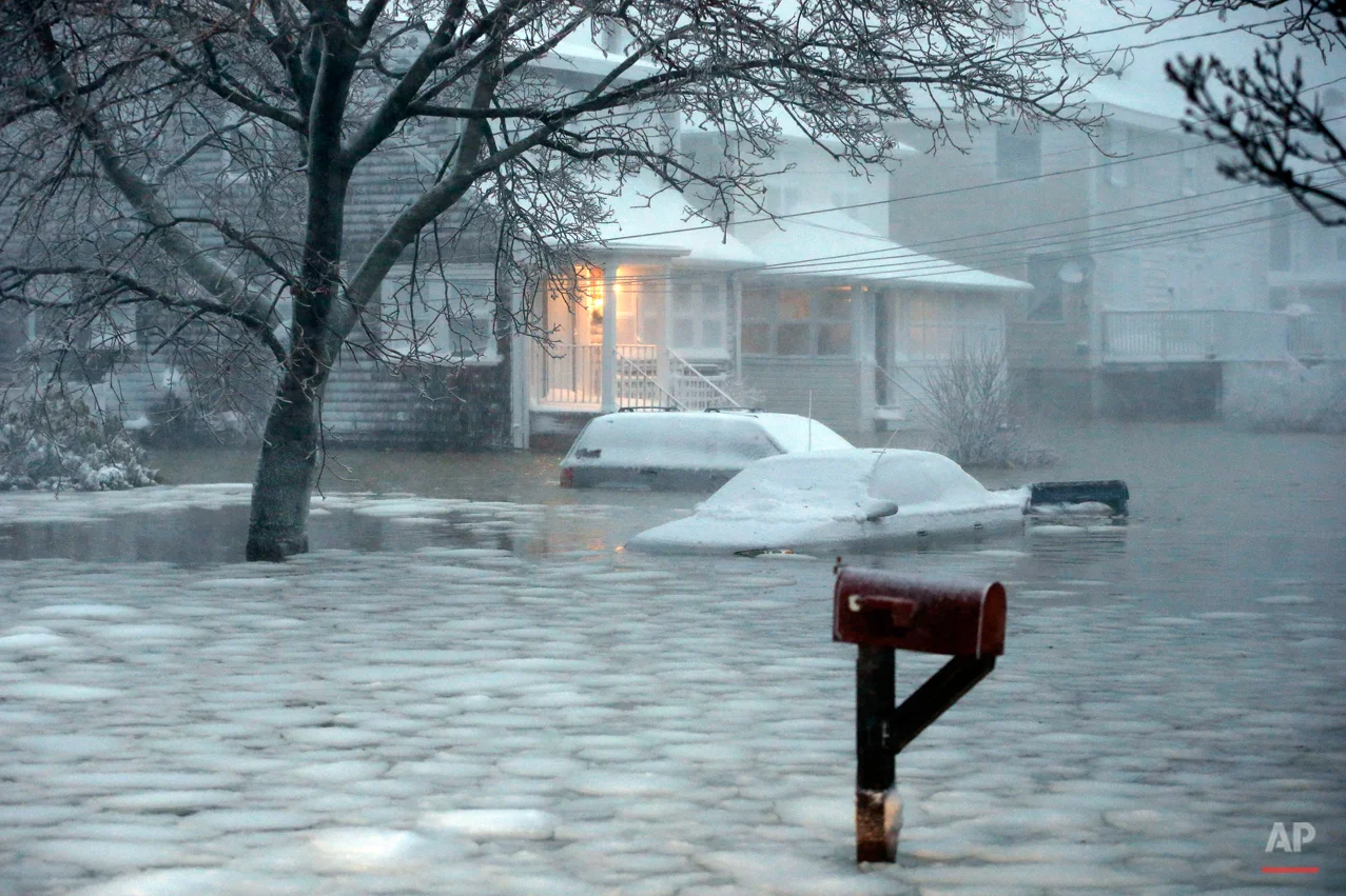Water floods a street on the coast in Scituate, Mass., Tuesday, Jan. 27, 2015. A storm packing blizzard conditions spun up the East Coast early Tuesday, pounding parts of coastal New Jersey northward through Maine with high winds and heavy snow. (AP Photo/Michael Dwyer)