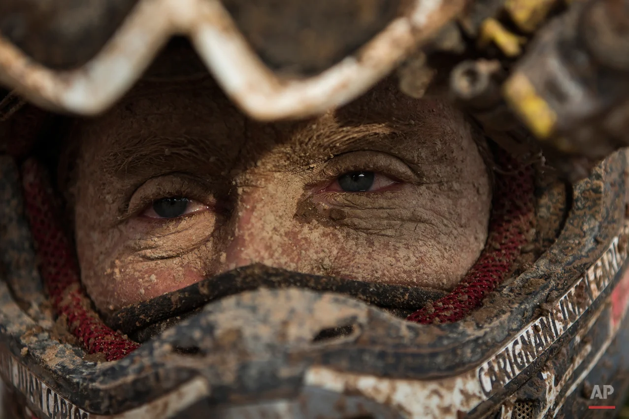 Yamaha quad rider Juan Carlos Carignani, from Italy, arrives with his face covered in dirt at the Uyuni camp after completing the seventh stage of the Dakar Rally 2015 between Iquique, Chile, and Uyuni, Bolivia, Sunday, Jan. 11, 2015. The race will finish on Jan. 17, passing through Bolivia and Chile before returning to Argentina where it started. (AP Photo/Felipe Dana)