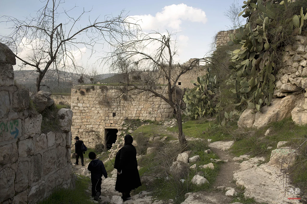 Ultra Orthodox Jewish family members tour in Lifta, located in Jerusalem's mountains, Thursday, Jan. 30, 2014. (AP Photo/Oded Balilty)