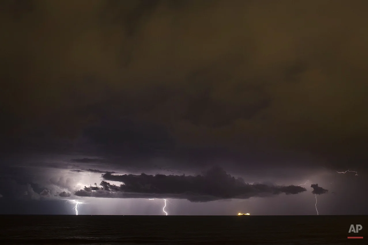 Lightning strikes down during a storm over the Mediterranean sea near a cargo ship off the coast near Michmoret, Israel, Monday, Nov. 24, 2014. (AP Photo/Ariel Schalit)
