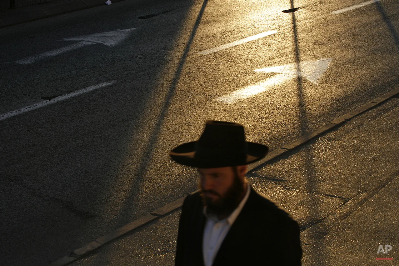 An ultra-Orthodox Jewish man walks in central Jerusalem at sunset, Wednesday, April 2, 2008. (AP Photo/Ed Ou)