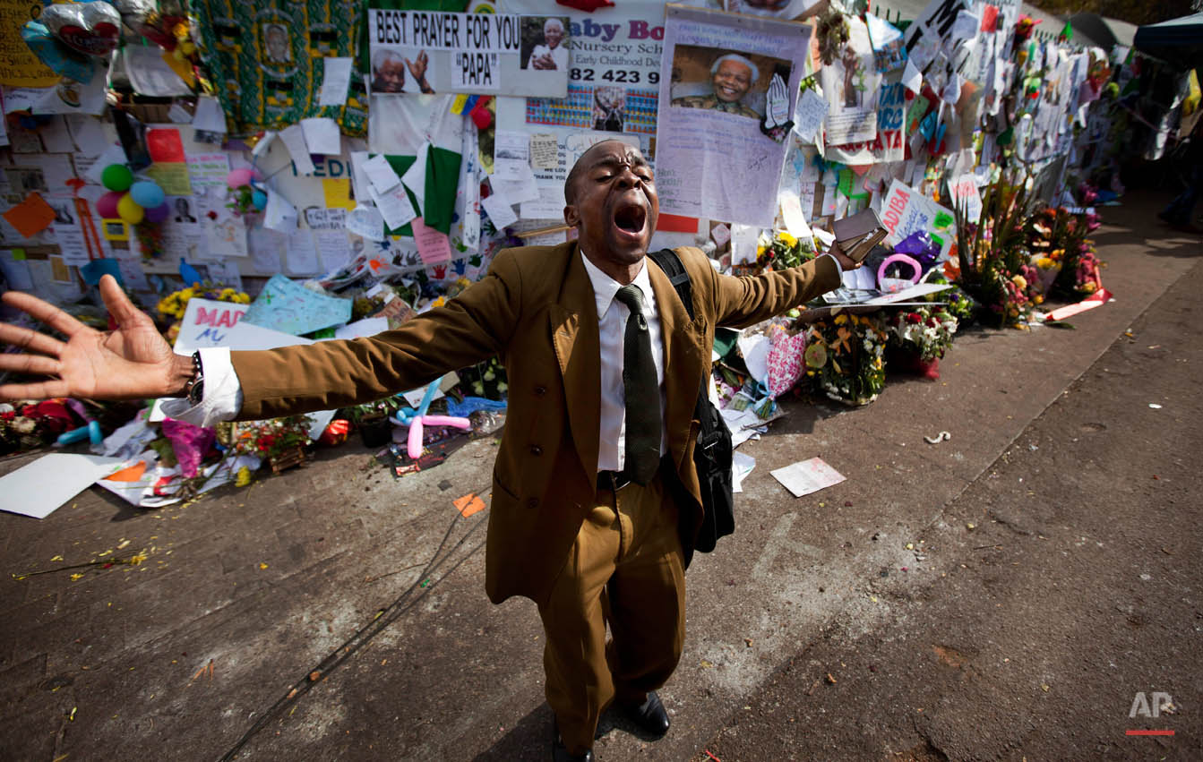  Gift Mapuka, who described himself as a "Global Mission Pioneer" from the Seventh-day Adventist Church, preaches on his own about Jesus and Nelson Mandela, in front of a wall of get-well messages and flowers left by well-wishers, outside the entranc