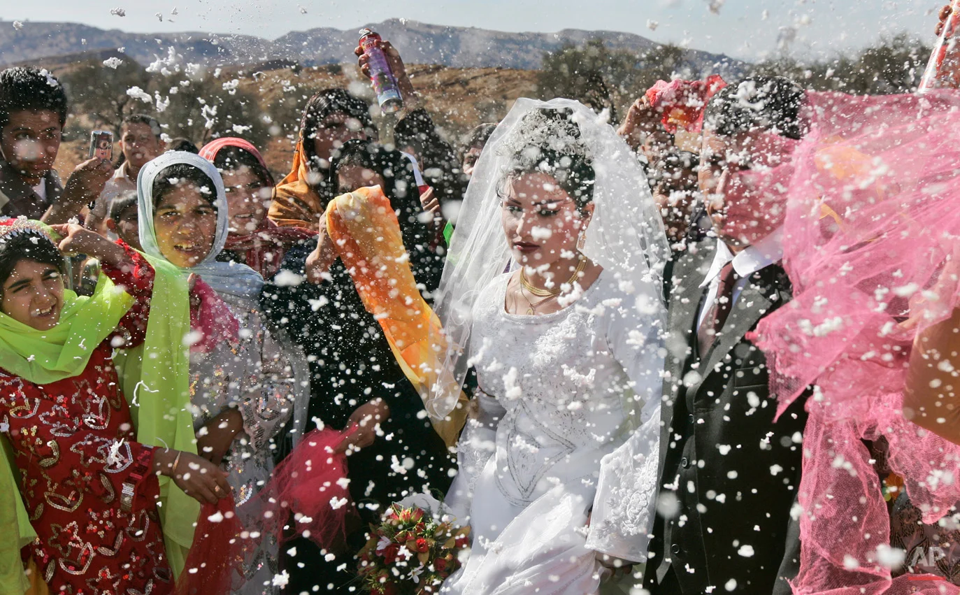 Villagers spray the groom, Mohammed Zamanpour, 25, and his bride Manijeh, 16, with foam confetti at a Bakhtiari nomad wedding in the mountain village of Abid near the town of Masjid-e-Soleiman in southwestern Iran, Thursday, Nov. 29, 2007. Migration has been a way of life for nomads such as the Bakhtiari in Iran for thousands of years but the phenomenon is slowly disappearing as government encroaches and the attractions of urban life draw some away from the nomadic lifestyle. (AP Photo/Ben Curtis)