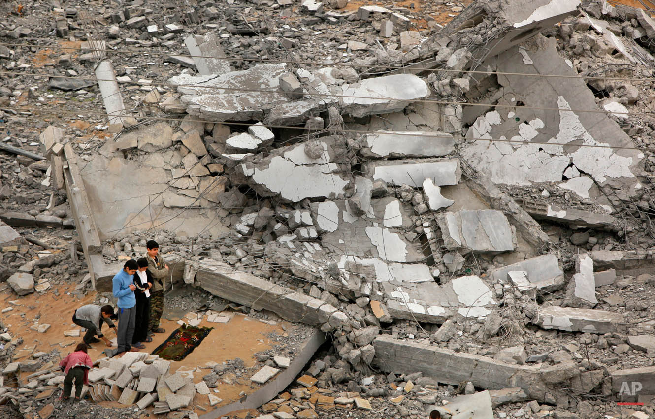  Palestinians offer traditional Muslim Friday prayers amidst the rubble of a destroyed mosque, where only the minaret still stands, in Beit Lahiya in the Gaza strip, Friday, Jan. 23, 2009. Gaza residents headed for Friday communal prayers and Israeli