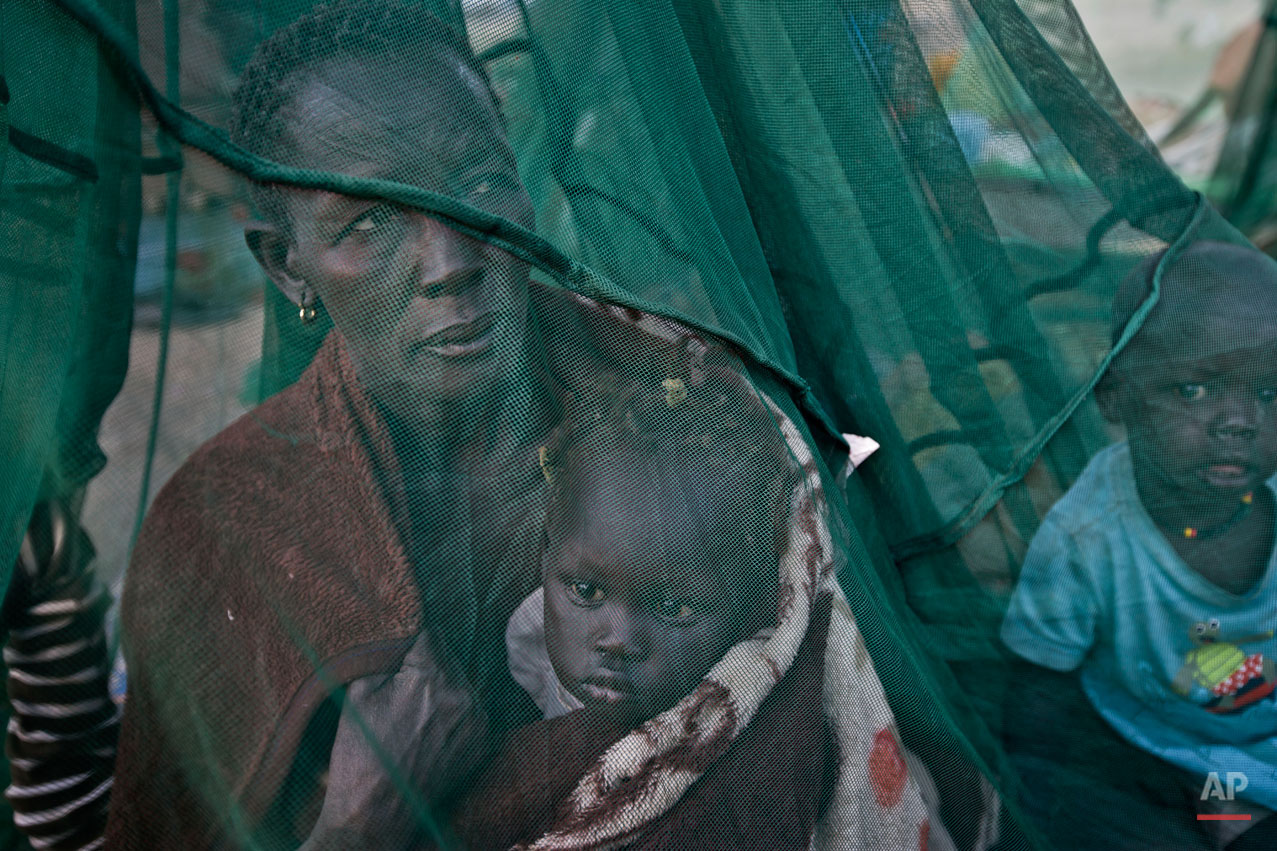  One of the few to have a mosquito net, a displaced family who fled the recent fighting between government and rebel forces in Bor by boat across the White Nile, sit under it after waking up in the morning in the town of Awerial, South Sudan Thursday