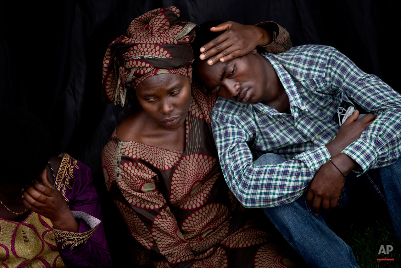  Bizimana Emmanuel, who was born two years before the genocide, is consoled by an unidentified woman while attending a public ceremony to mark the 20th anniversary of the Rwandan genocide, at Amahoro stadium in Kigali, Rwanda Monday, April 7, 2014. S