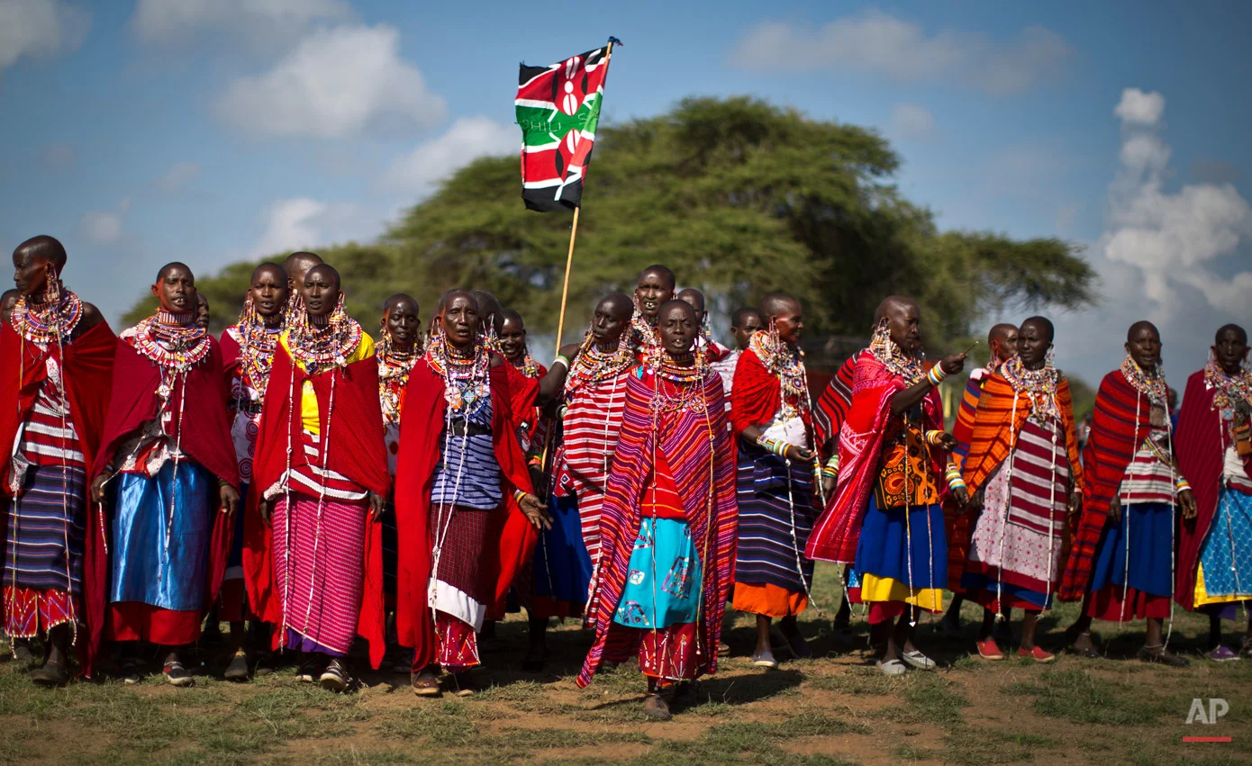 A group of Maasai women arrive to support the young warriors from their village at the annual Maasai Olympics in the Sidai Oleng Wildlife Sanctuary near to Mt Kilimanjaro, in southern Kenya Saturday, Dec. 13, 2014. Maasai men and women from the Amboseli and Tsavo region compete for medals and prizes in the event which aims for a sports competition of Maasai skills such as running, jumping, and throwing, to replace lion-hunting as the traditional warrior activity. (AP Photo/Ben Curtis)