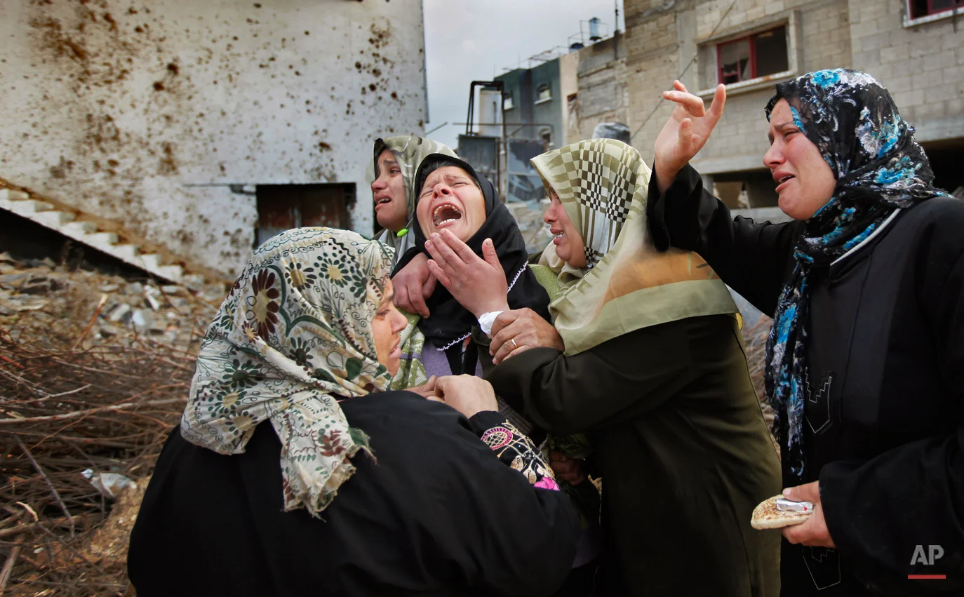 A Palestinian woman from the Suboh family weeps as she is comforted after learning the body of a releative was dug out of the rubble of a house destroyed in recent days in Israeli bombardment in Beit Lahiya, northern Gaza strip, Monday, Jan. 19, 2009. The bodies of four Hamas fighters from the same family, Bassem, Nashad, Sharif, and Rizek Suboh, were pulled from the rubble in the are that was hit hard in an Israeli miltary offensive. Israel hopes to pull all its troops out of the Gaza Strip by the time Barack Obama is inaugurated as president of the United States on Tuesday, Israeli officials (AP Photo/Ben Curtis)