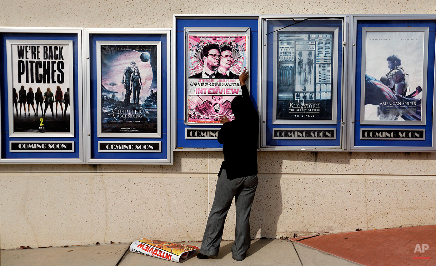  A poster for the movie “The Interview” is taken down by a worker after being pulled from a display case at a Carmike Cinemas movie theater, Wednesday, Dec. 17, 2014, in Atlanta. Georgia-based Carmike Cinemas has decided to cancel its planned showing