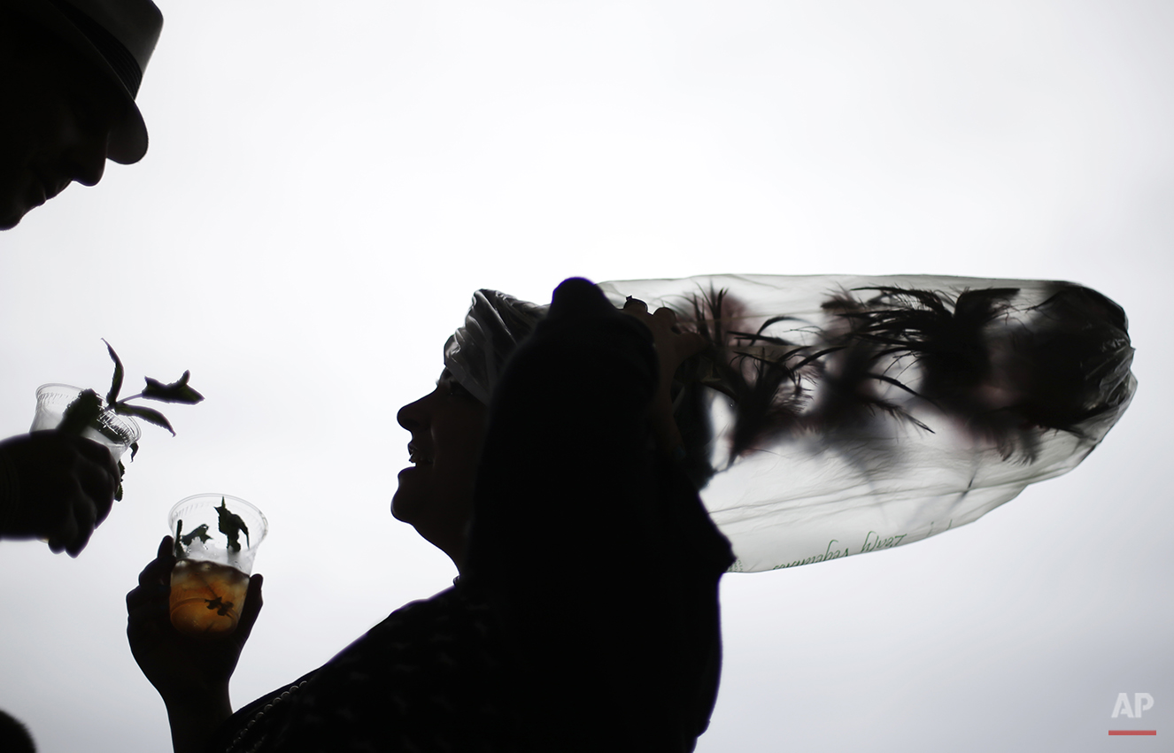  Desirae Masterson, from Indianapolis, Ind., with her hat covered in a plastic bag to protect it from the rain, shares a mint julep with her husband Ray before the running of the 139th Kentucky Derby at Churchill Downs Saturday, May 4, 2013, in Louis