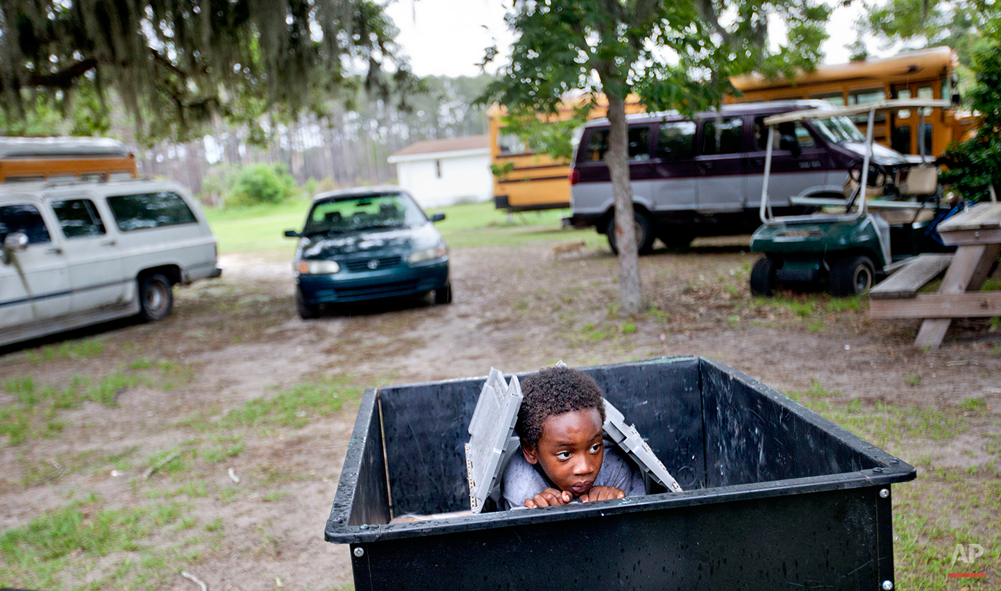  Jermarkest Wilson, 7, plays in a cart in the backyard of his home on Sapelo Island, Ga. on Sunday, June 9, 2013. Eight children catch a ferry every morning to attend school on the mainland since the last school operating on the island closed in 1978