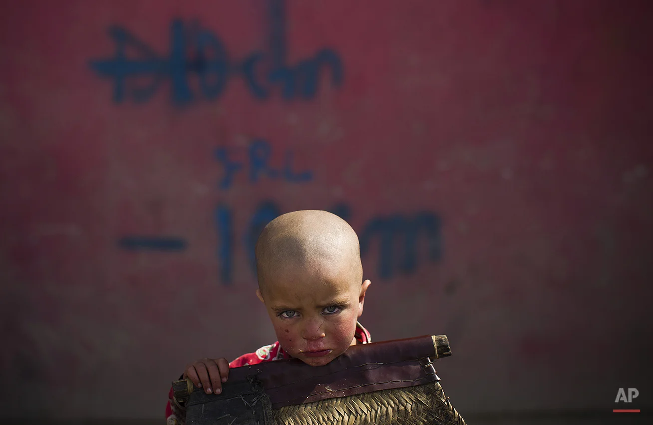 An Afghan child sit next to the shop of his father in the old city of Kabul, Afghanistan, Saturday, March 3, 2012. (AP Photo/Anja Niedringhaus)