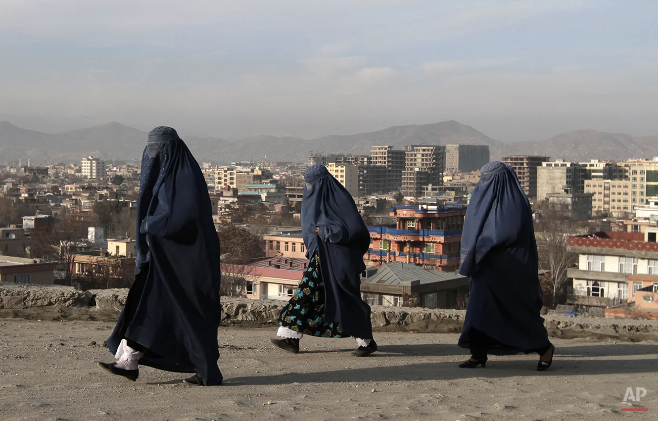 Afghan women walk along on the street in Kabul, Afghanistan, Friday, Dec. 20, 2013. (AP Photo/Rahmat Gul)