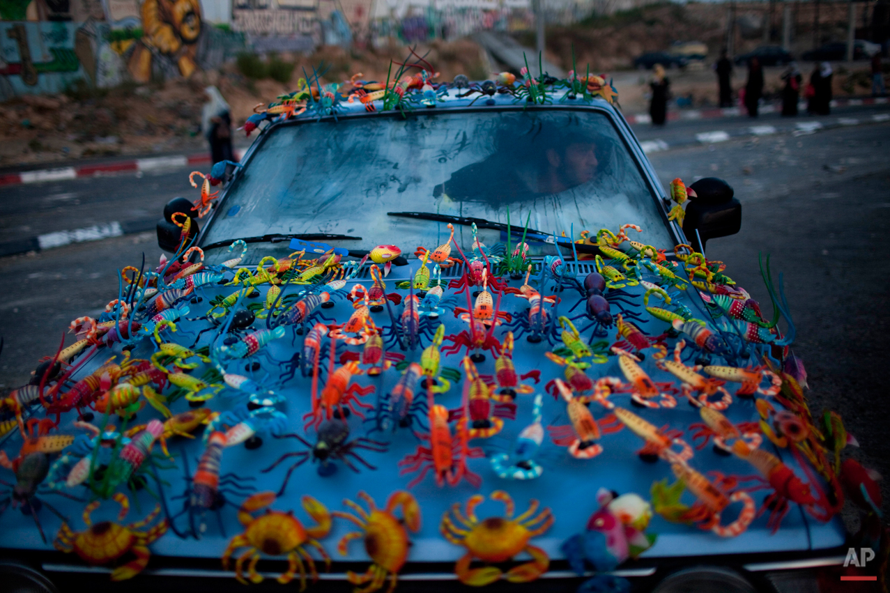  Magnets for sale are displayed on the car of a Palestinian man at the Kalandia checkpoint, between Jerusalem and the West Bank city of Ramallah, Friday, Aug. 13, 2010. (AP Photo/Bernat Armangue) 