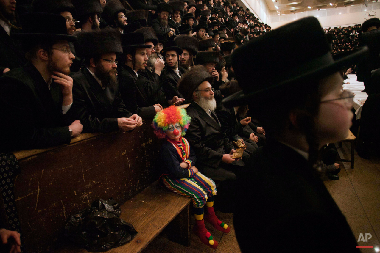  A child dressed in a clown costume, participates with other Ultra-Orthodox Jewish men in the Purim festival at a synagogue in Jerusalem, Thursday, March 8, 2012. The Jewish holiday of Purim celebrates the Jews' salvation from genocide in ancient Per