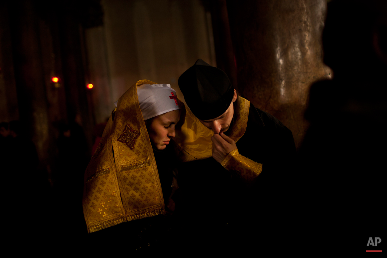 An Orthodox priest hears confession of a nun inside the Church of the Nativity, traditionally believed by Christians to be the birthplace of Jesus Christ, during Orthodox Christmas celebrations in the West Bank city of Bethlehem, late Friday, Jan. 6, 2012. (AP Photo/Bernat Armangue)
