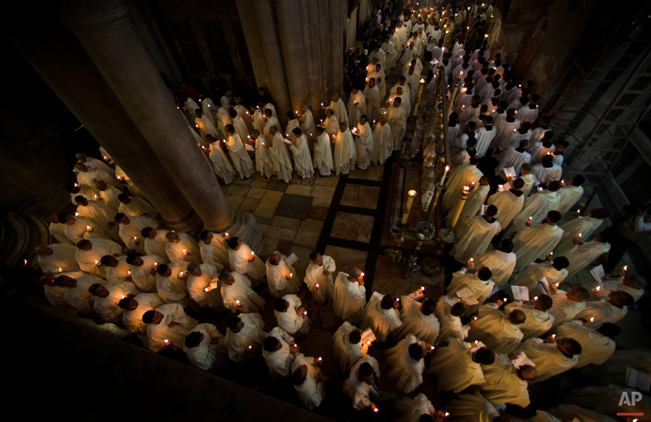 Catholic clergy walk holding candles during the Holy Thursday procession of the Washing of the Feet inside the Church of the Holy Sepulchre, traditionally believed to be the burial site of Jesus Christ, in Jerusalem's Old City, Thursday, April 5, 2012. (AP Photo/Bernat Armangue)