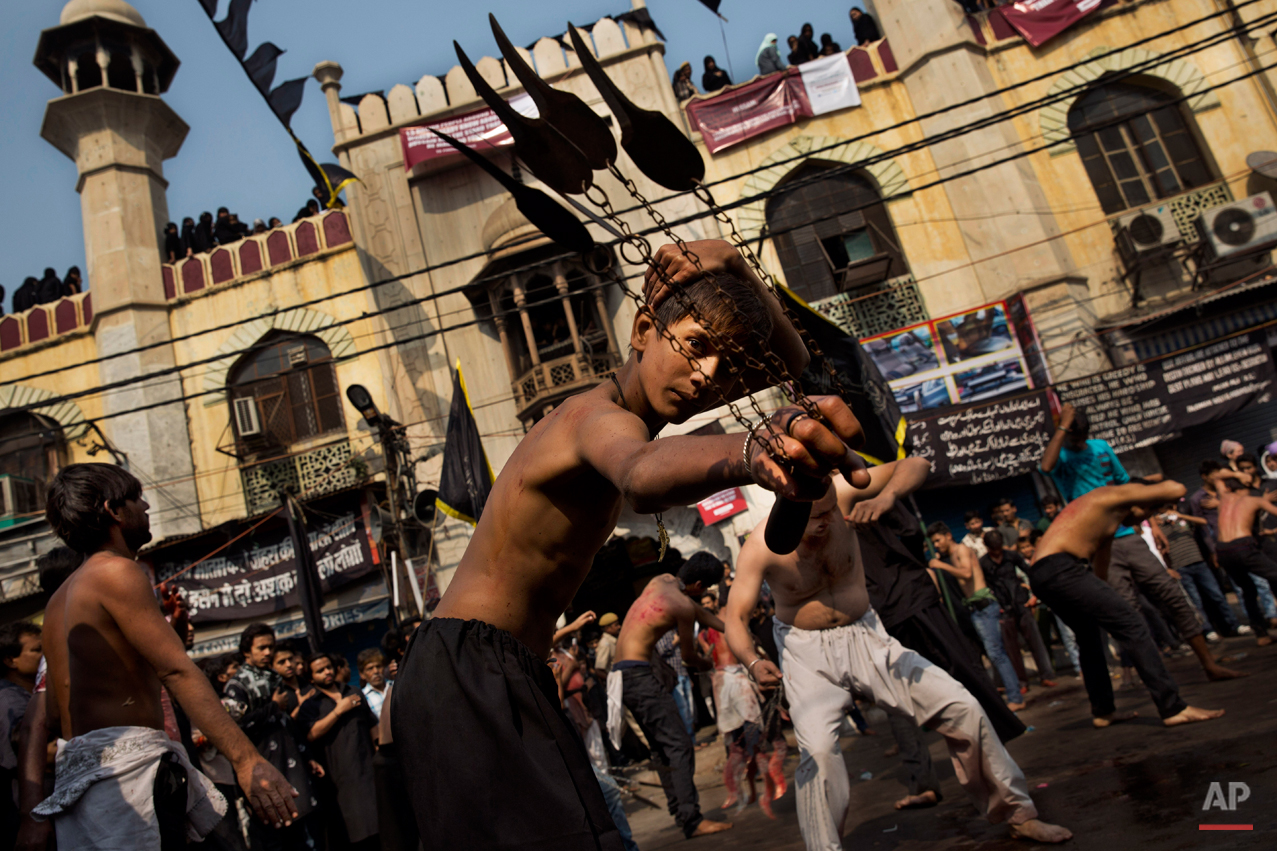 A young Indian Shiite Muslim flagellates himself during a procession to mark Ashoura in New Delhi, India, Tuesday, Nov. 4, 2014. Shiites mark Ashoura, the tenth day of the month of Muharram, to commemorate the Battle of Karbala when Imam Hussein, a grandson of Prophet Muhammad, was killed. (AP Photo/Bernat Armangue)