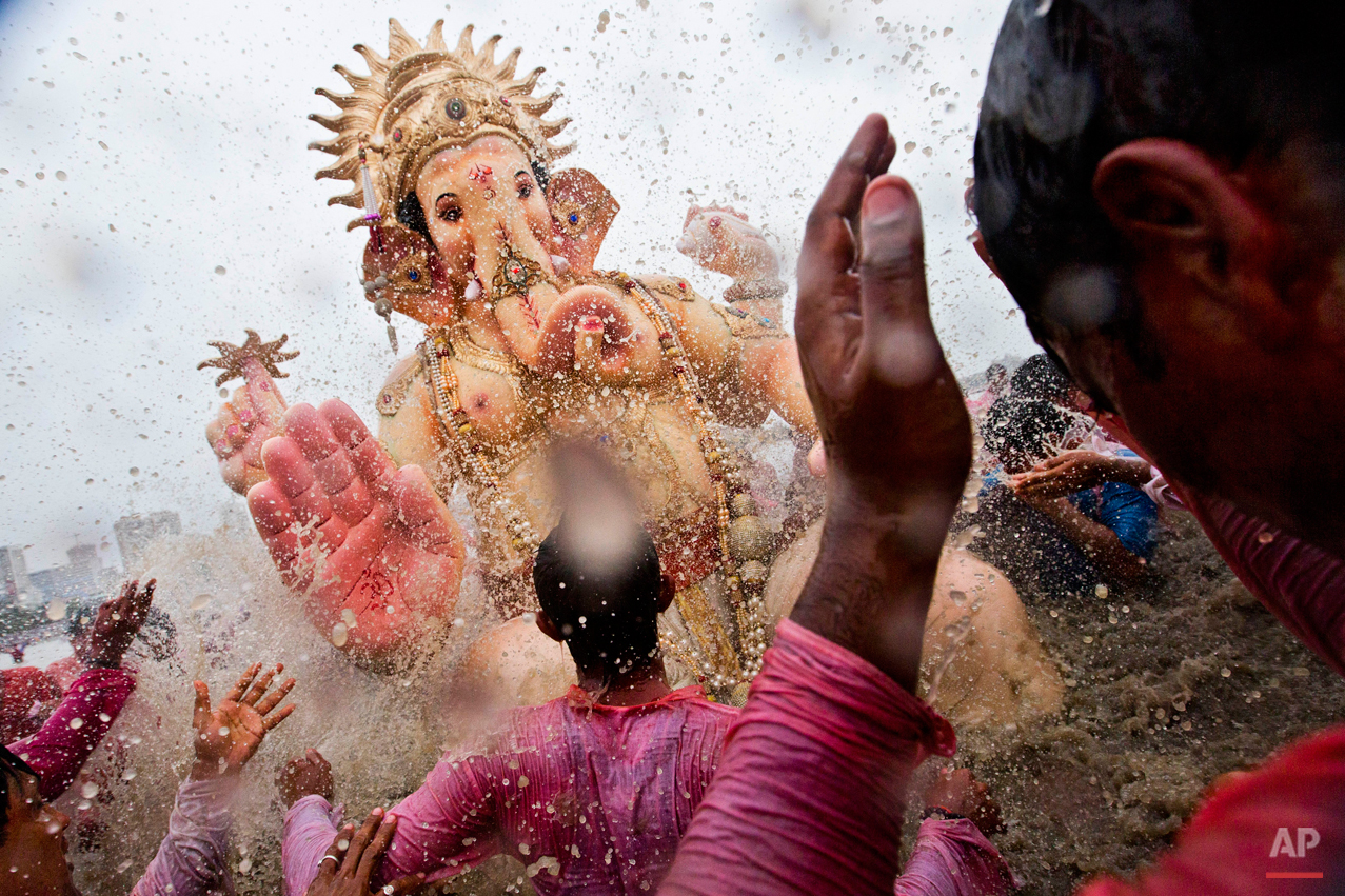  Indian Hindu devotees splash water on a large statue of the elephant-headed Hindu God Ganesha before immersing it in the Arabian Sea on the final day of the festival of Ganesha Chaturthi in Mumbai, India, Monday, Sept. 8, 2014. (AP Photo/Bernat Arma