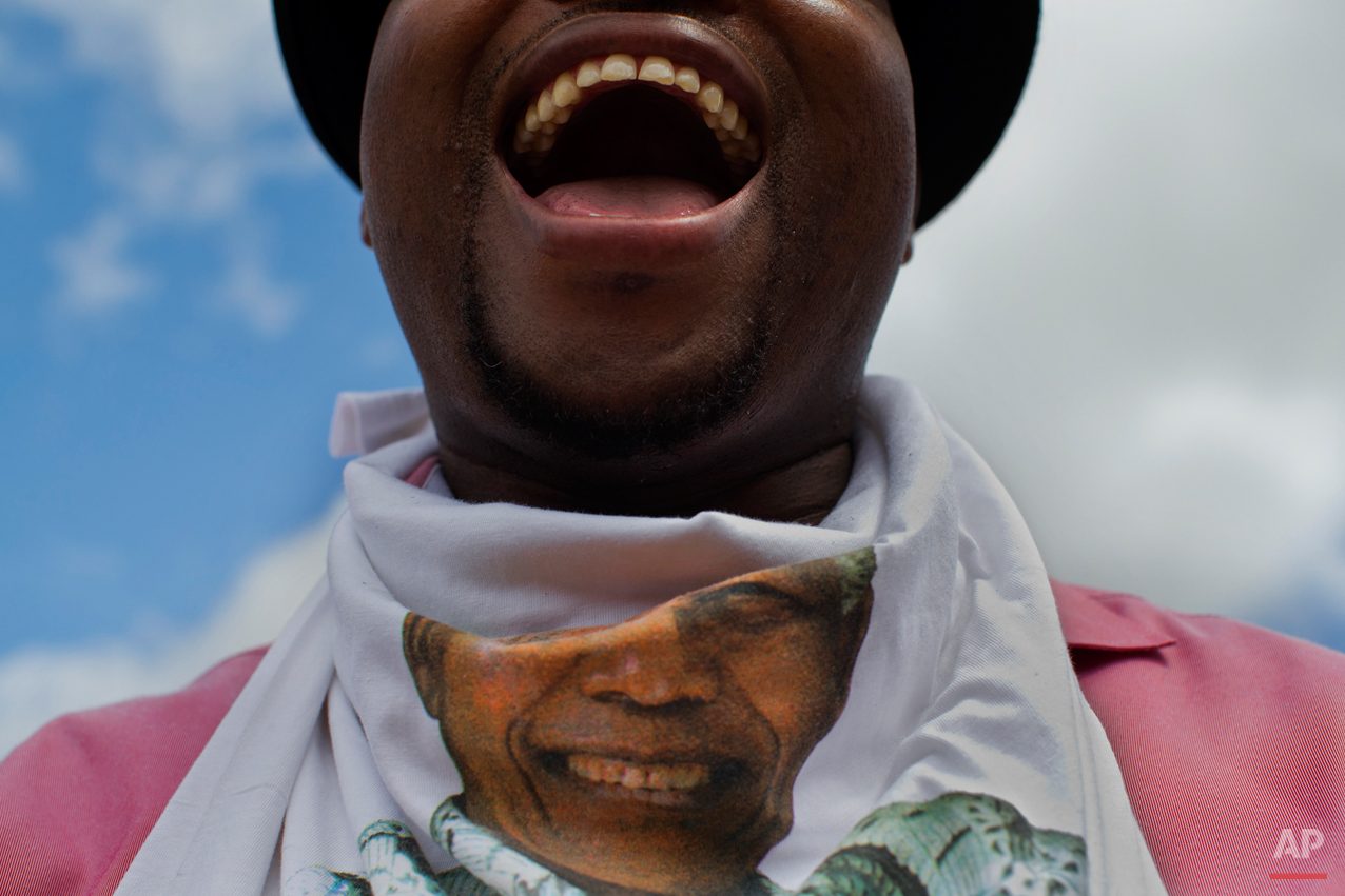  Khanyile Diko cheers while waiting for the motorcade transporting the body of Nelson Mandela in the town of Mthatha on its way to Qunu, South Africa Saturday, Dec. 14, 2013. (AP Photo/Bernat Armangue) 