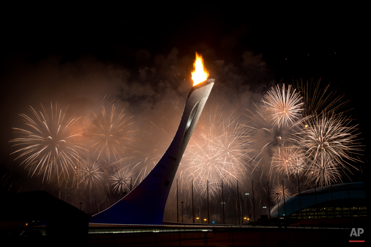  Fireworks explode behind the Olympic torch after it was lit at end of the opening ceremony for the 2014 Winter Olympics in Sochi, Russia, Friday, Feb. 7, 2014. (AP Photo/Bernat Armangue) 
