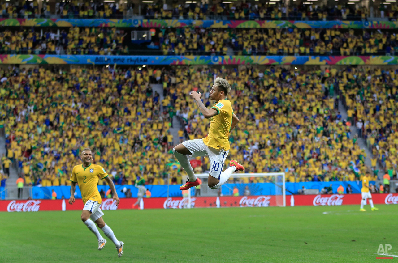  Brazil's Neymar leaps in the air to celebrate after scoring his side's second goal during the group A World Cup soccer match between Cameroon and Brazil at the Estadio Nacional in Brasilia, Brazil, Monday, June 23, 2014. (AP Photo/Bernat Armangue) 