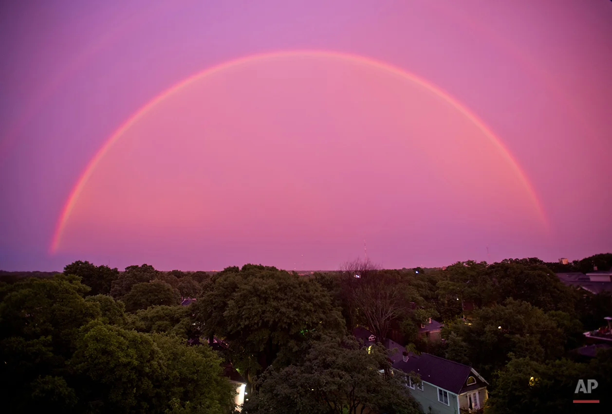 The sky turns pink as a rainbow appears at dusk after a thunderstorm, Thursday, June 5, 2014, in Atlanta. (AP Photo/David Goldman)