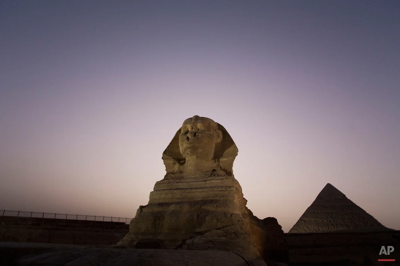 Journalists visit the Sphinx, with the body of a lion and a human head, on a media tour following the completion of restoration work in preparation for the reopening of the courtyard around its base, in front of the Khafra pyramid, Giza, near Cairo, Egypt, Sunday, Nov. 9, 2014. (AP Photo/Hiro Komae)