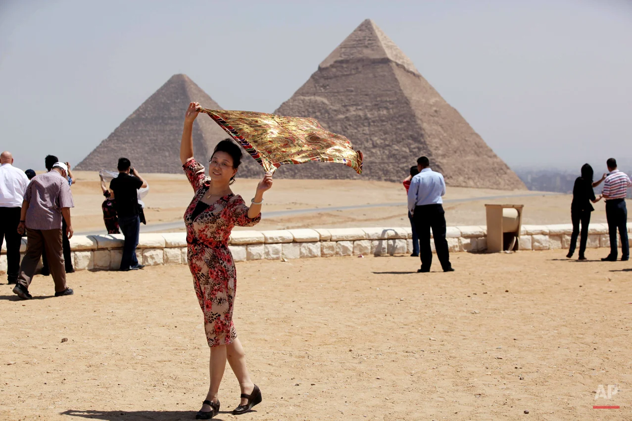 A tourist poses for a photographer, unseen, at the historical site of the Giza Pyramids, near Cairo, Egypt, Tuesday, Aug. 27, 2013. Tourism in Egypt has dropped following unrest surrounding the July 3 popularly backed military coup that ousted President Mohammed Morsi. (AP Photo/Jon Gambrell)