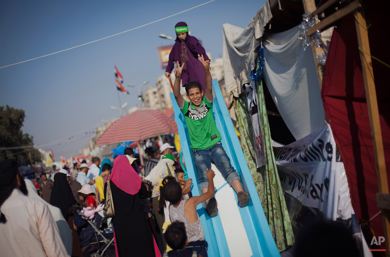  Egyptian children play on a slide set up next to a tent outside Rabaah al-Adawiya mosque, where supporter of Egypt's ousted President Mohammed Morsi have installed a camp and held daily rallies at Nasr City, in Cairo, Egypt, Saturday, Aug. 10, 2013.