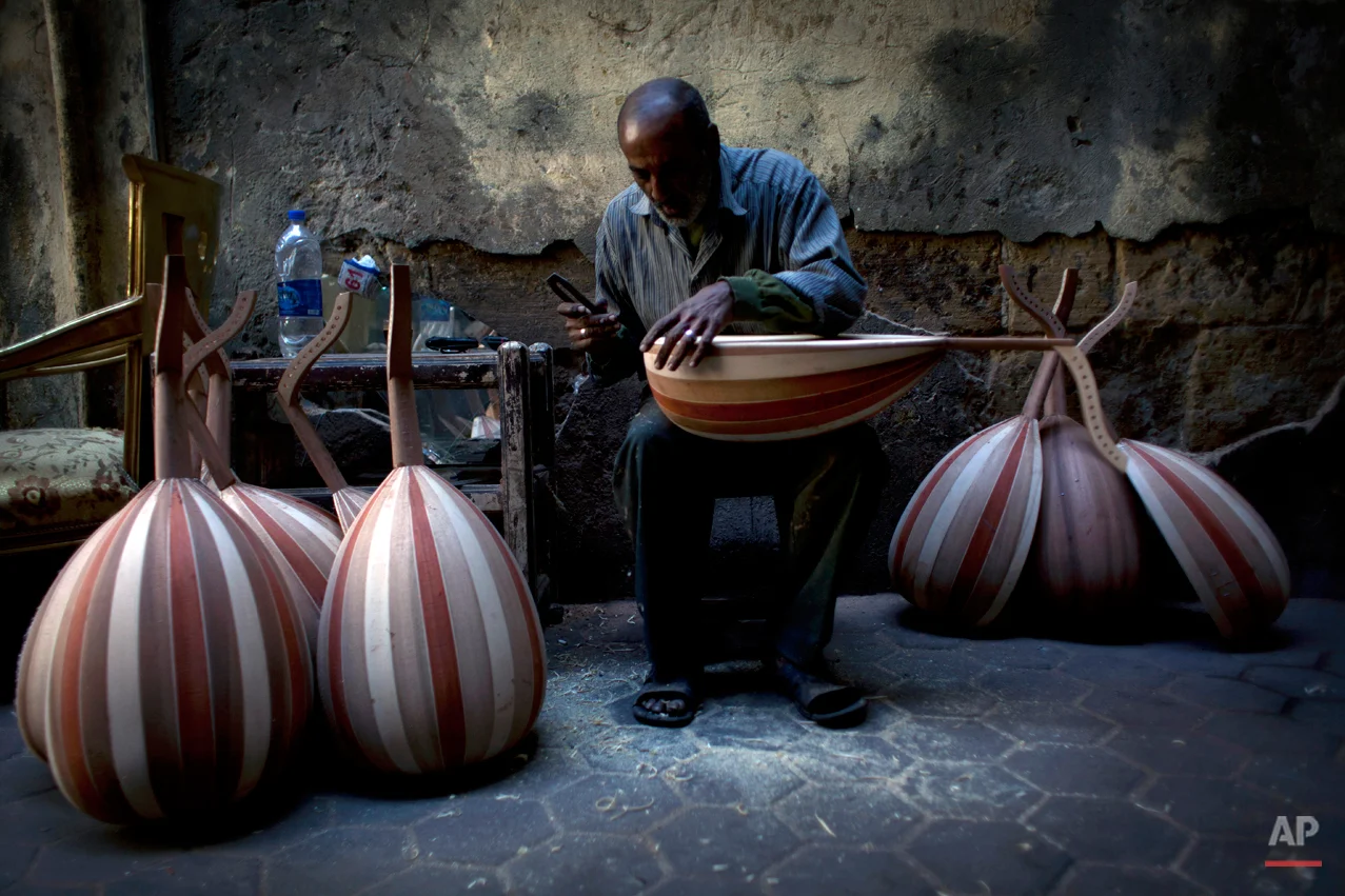 In this Thursday, Jan. 3, 2013 photo, Egyptian artisan, Mohammed Karam, 55 works on an oud at his workshop on Mohammed Ali street, a street modeled after Parisí boulevards, home to musicians, belly-dancers and instrument makers, in downtown Cairo, Egypt. The shops making, repairing and selling musical instruments that once packed the street are disappearing along with their window displays of lute-like, stringed ouds, qanouns and tablas -- a drum made equally for the rapid-fire hand beats of belly-dance tunes or for the languid rhythms of a love ballad by Umm Kalthoum, the most famed singer of classical Arabic music. (AP Photo/Nasser Nasser)