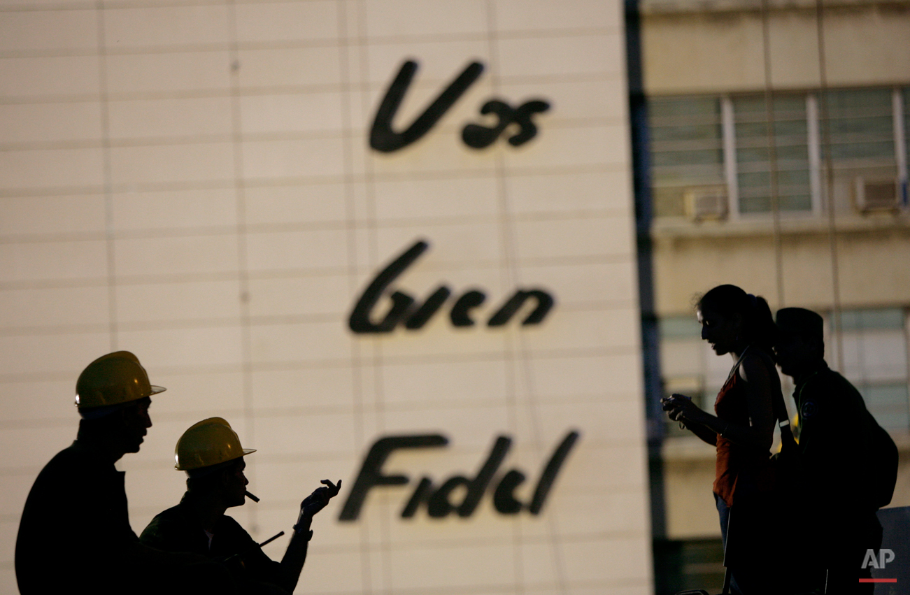  Workers talk next to a wall where a sculpture in honor of the late revolutionary commander Camilo Cienfuegos will be installed at the Revolution square in Havana, Monday, Oct. 26, 2009. The sculpture, created by artist Enrique Avila, will be inaugur