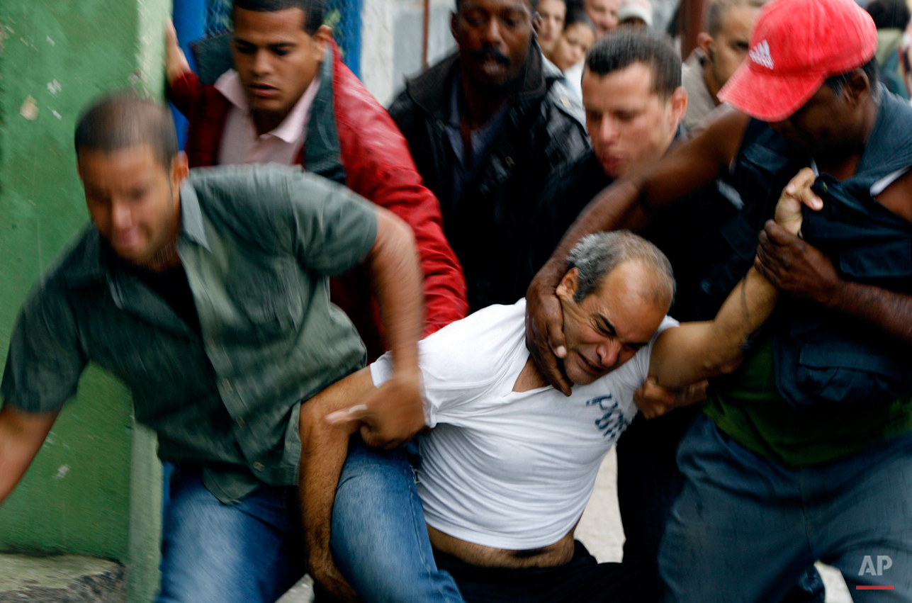  A demonstrator is taken away from the street by security agents during a protest in Havana, Wednesday, March 17, 2010. Cuban security agents prevented Ladies in White, a group of female dissidents, from marching on the outskirts of the capital to de