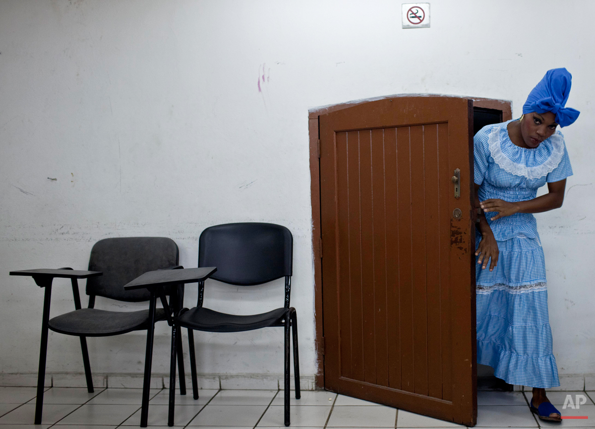  In this May 23, 2014 photo, Yusanelis Moras leaves of a room before a performance in Havana, Cuba. Obini Bata is the first orchestra of percussionists made up of women who dared to drum bata drums. Under Afro-Cuban beliefs, the two-sided bata (prono