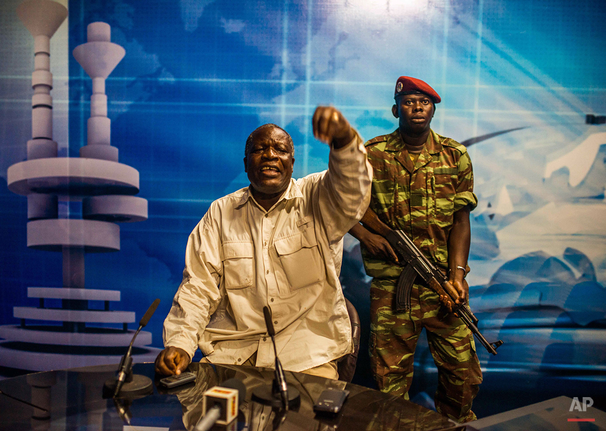  Burkina Faso army Gen. Kwame Lougue, center, with a armed guard at the state television studios, after he entered without speaking to journalists who were waiting  for a announcement by opposition politician Saran Sereme, shorty after gun shots were