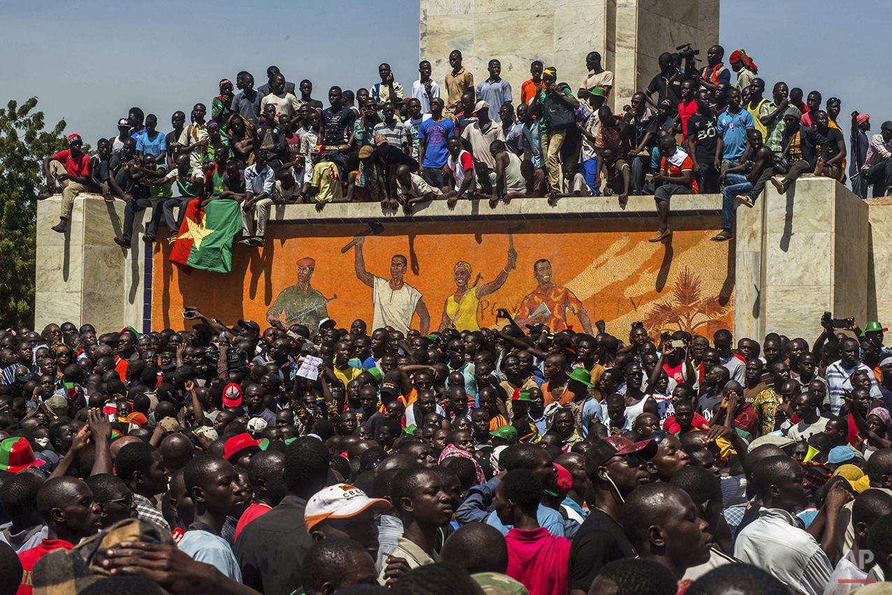  People gather near a government building as they await the announcement of a new interim leader in Ouagadougou, Burkina Faso, Friday, Oct. 31, 2014. An army general stepped into the vacuum left in Burkina Faso on Friday by the resignation President 