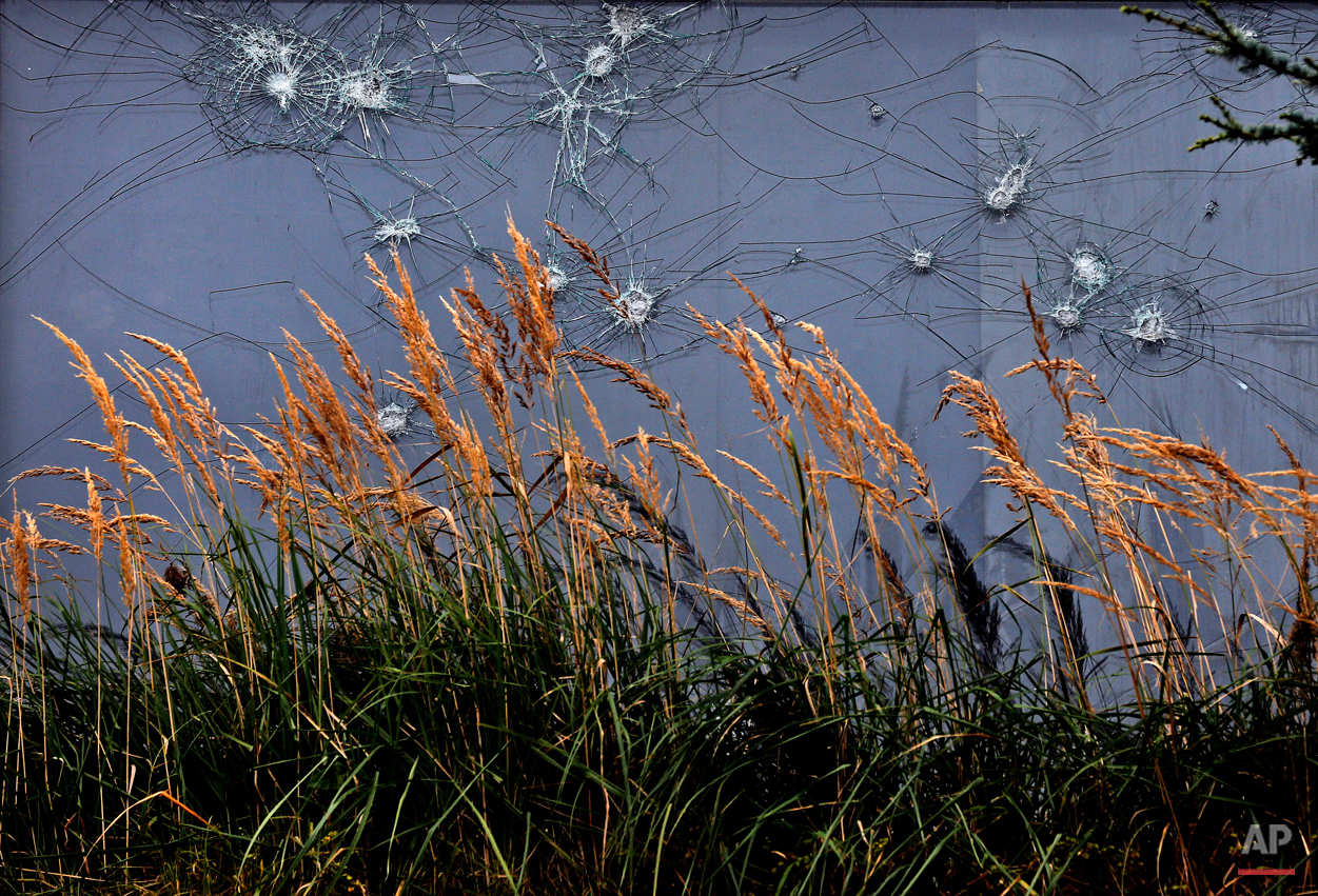  In this Sept. 26, 2014 photo, grass grows in front of a damaged house window in Immerath, Germany. Immerath has become a ghost town to be demolished for the approaching brown coal mining. Inhabitants were relocated to a new town. (AP Photo/Frank Aug