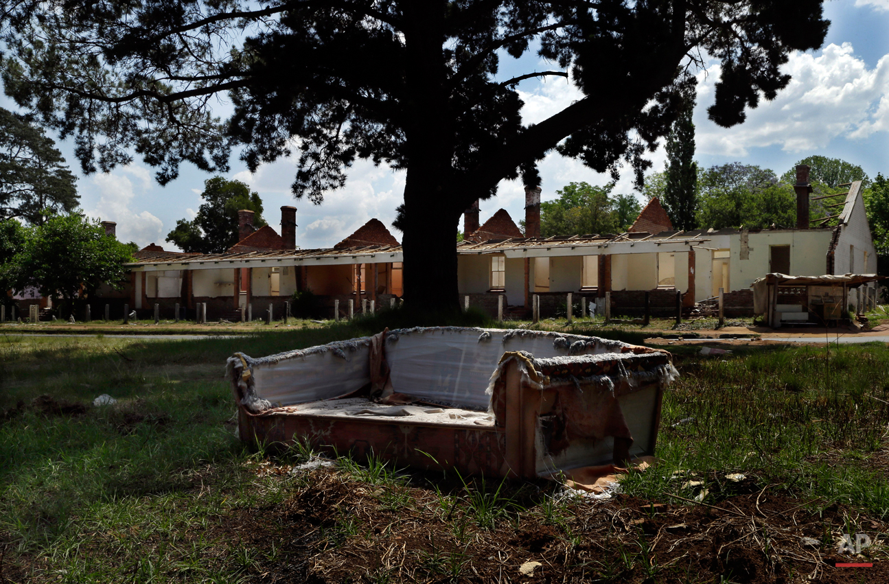  This Oct. 24, 2014, photo shows a broken coach placed next a road nearby abandoned houses at Durban Deep mine residential area in Roodepoort, west of Johannesburg, South Africa. The once sought-after mining facility at Durban Deep now is in a crime-