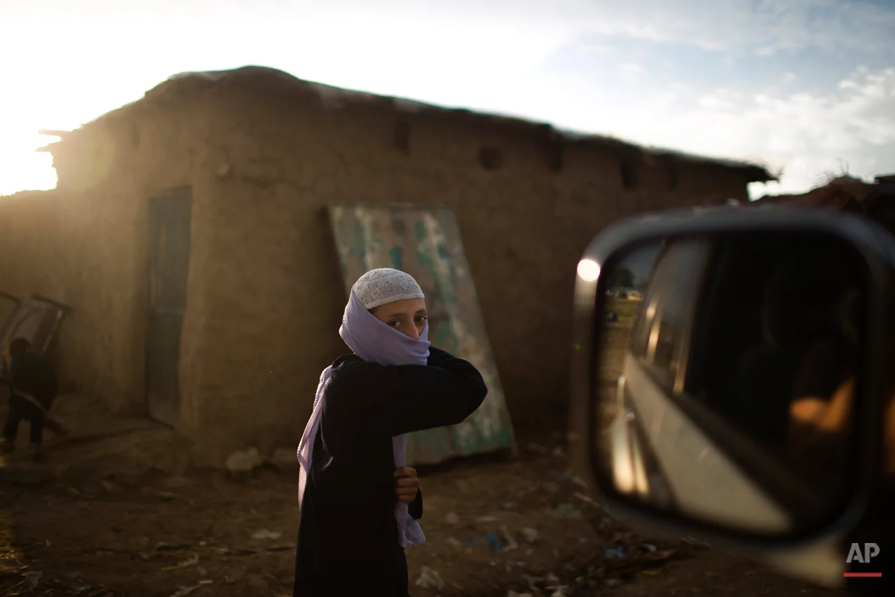 An Afghan refugee boy, wearing new clothes, walks toward a mosque, on the Muslim holiday of Eid al-Adha, or Feast of Sacrifice, on the outskirts of Islamabad, Pakistan, Monday, Oct. 6, 2014. Muslims around the world celebrate Eid to commemorate what Muslims believe was Prophet Abraham's willingness to sacrifice his son Ismail. Because the holiday follows the Muslim lunar calendar that depends on sightings of the moon, the holiday started on Monday in Pakistan. (AP Photo/Muhammed Muheisen)