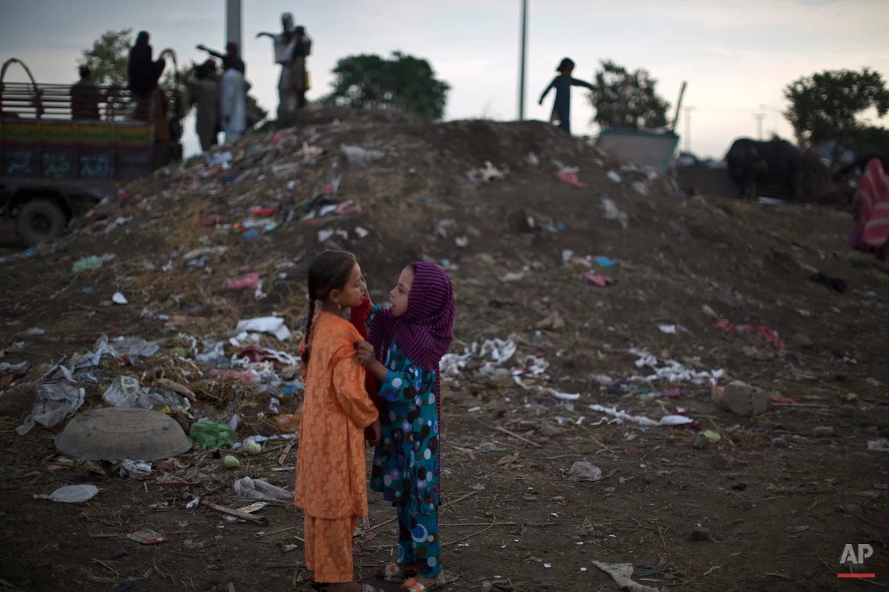 An Afghan refugee applies makeup to her friend as they celebrate the Muslim holiday of Eid al-Adha, or Feast of Sacrifice, on the outskirts of Islamabad, Pakistan, Monday, Oct. 6, 2014. Muslims around the world celebrate Eid al-Adha, or the Feast of the Sacrifice, to commemorates what Muslims believe was Prophet Abraham's willingness to sacrifice his son Ismail. Because Eid follows the Muslim lunar calendar that depends on sightings of the moon the holiday starts on Monday in Pakistan. (AP Photo/Muhammed Muheisen)