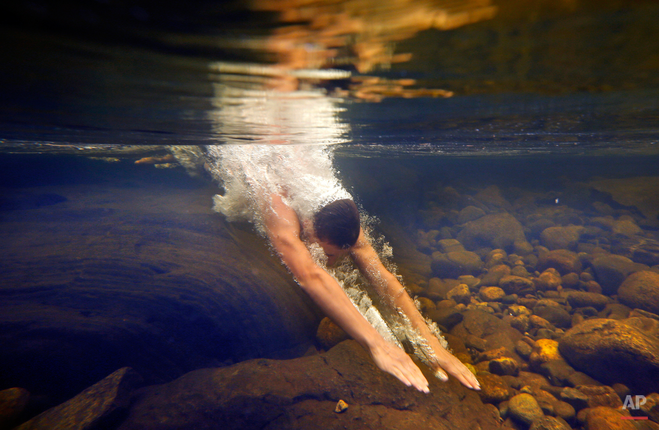  Russell Norris, 15, of Tylertown, Miss., dives into the chilly Swift River at Coos Canyon in Byron, Maine. The canyon is considered one of the premier swimming holes in the U.S. (AP Photo/Robert F. Bukaty) 