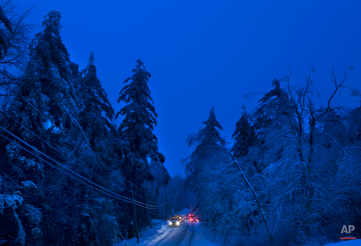 Utility crews prepare to work on power lines at dusk on Thursday, Dec. 26, 2013 in Litchfield, Maine, where many have been without electricity since Monday's ice storm. (AP Photo/Robert F. Bukaty) 