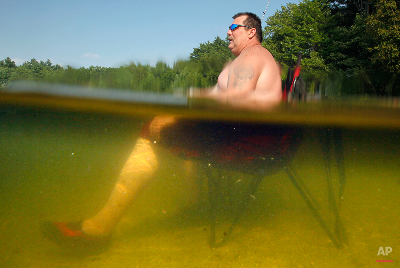  William Dyer, Jr., of Gortham, Maine stays cool seated on his beach chair waist-deep in Sabbathday Lake in New Gloucester, Maine, Thursday, July 21, 2011. The heat that has gripped much of the nation arrived in Maine on Friday. (AP Photo/Robert F. B