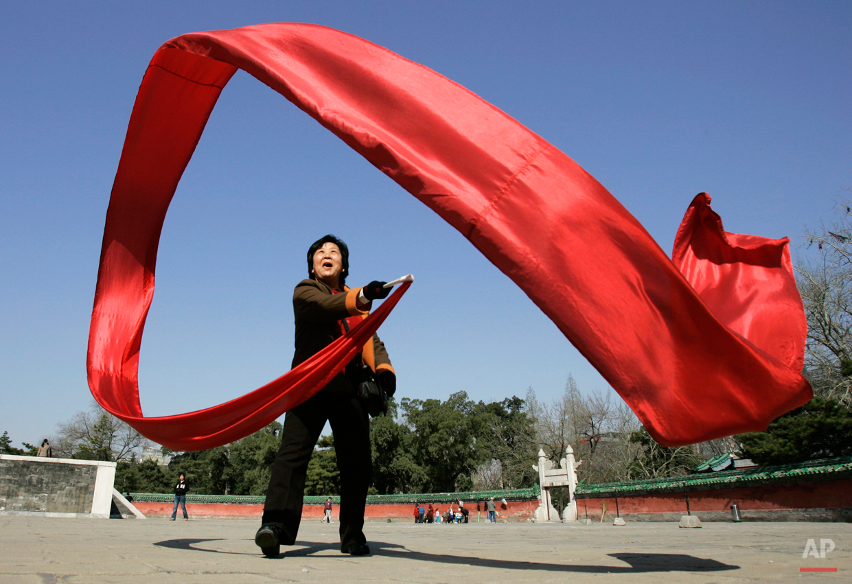  A woman waves a large red ribbon in a sweeping figure-eights as part of her morning exercise at Ritan Park, Friday, April 4, 2008, In Beijing. (AP Photo/Robert F. Bukaty) 