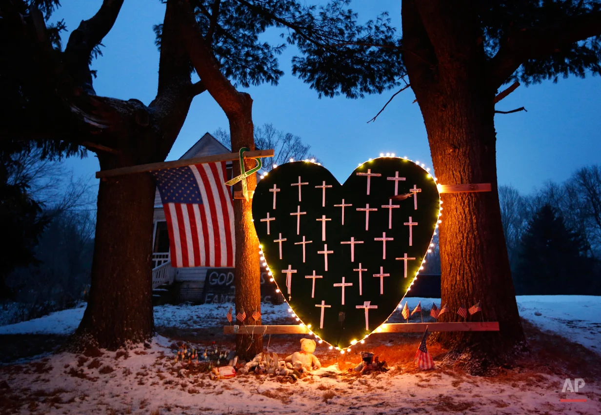FILE - In this Saturday, Dec. 14, 2013, file photo, a makeshift memorial with crosses for the victims of the Sandy Hook massacre stands outside a home in Newtown, Conn., the one-year anniversary of the shootings. Connecticut authorities said they planned Friday, Dec. 27, 2013, to release state police documents from the investigation into last year's Newtown school massacre. (AP Photo/Robert F. Bukaty, File)