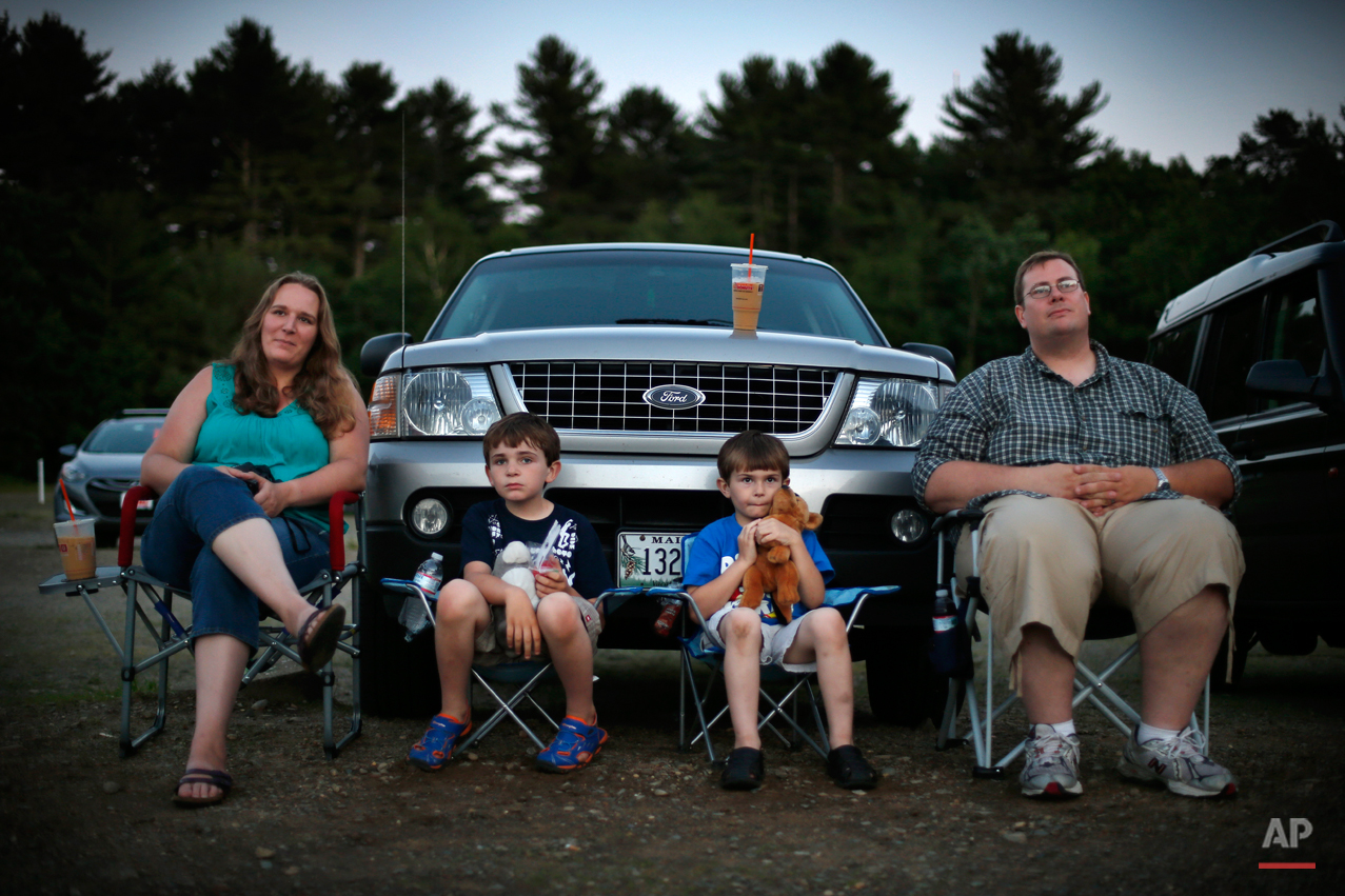  In this photo made Thursday, June 26, 2014, Jen and Philip Mason, along with their sons Skyelar, left, and Trysten, watch the previews at the Saco Drive-In in Saco, Maine. Many in the movie industry feared the need to convert to digital could be the